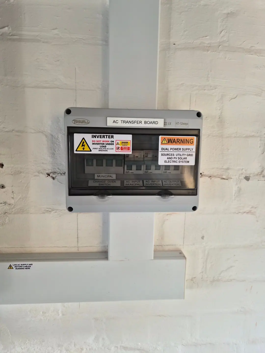 An AC transfer board with a changeover switch and warning labels