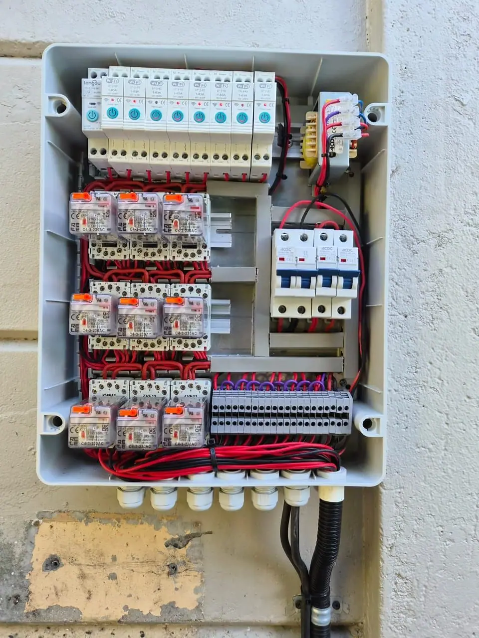 A control panel with relays, breakers and terminal blocks, wired and labelled