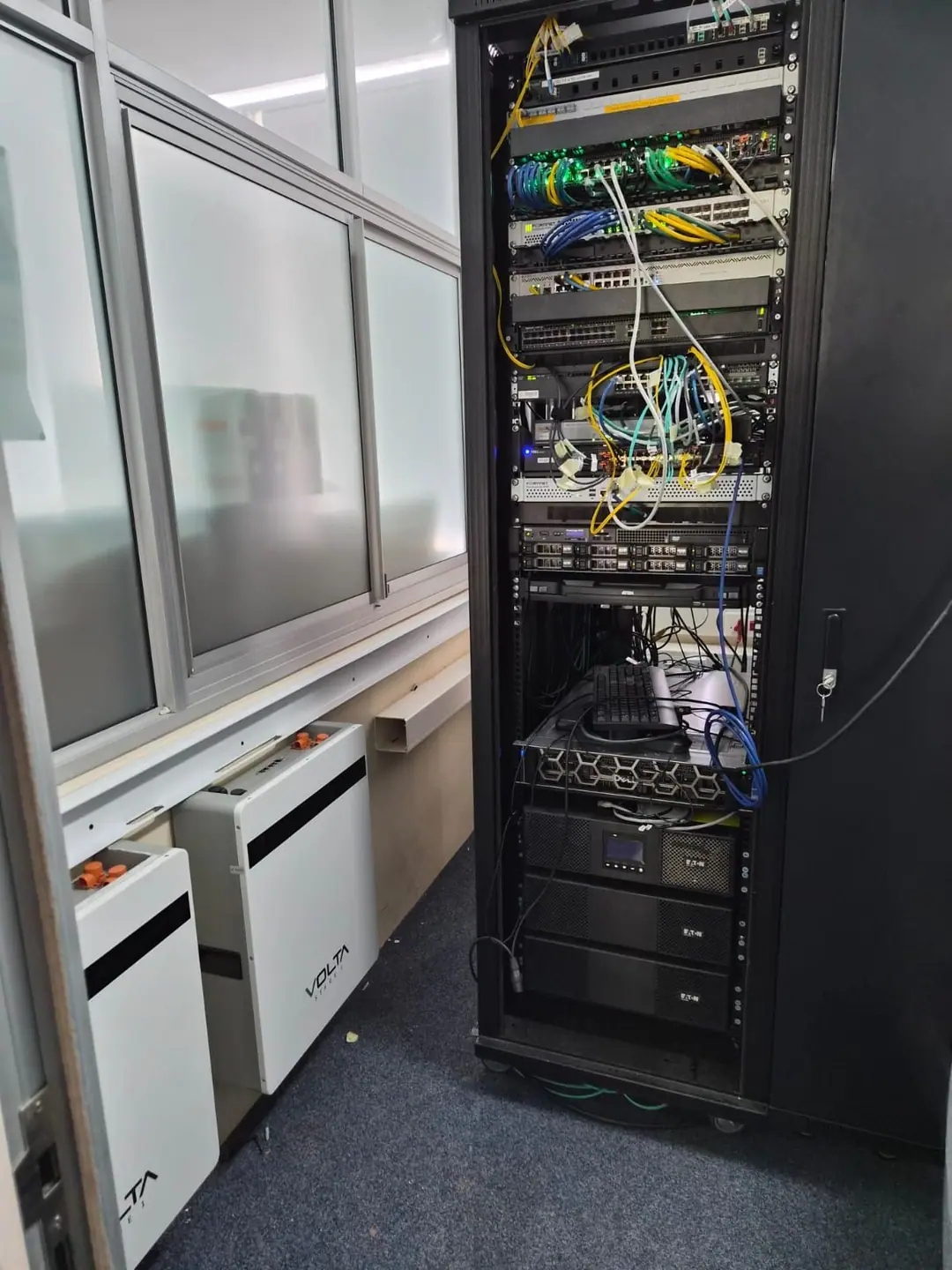 Lithium backup batteries installed beside a server rack in an office