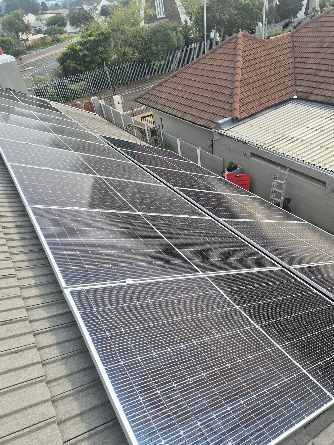 Rows of solar panels on a grey tiled roof, fitted flush to the roofline