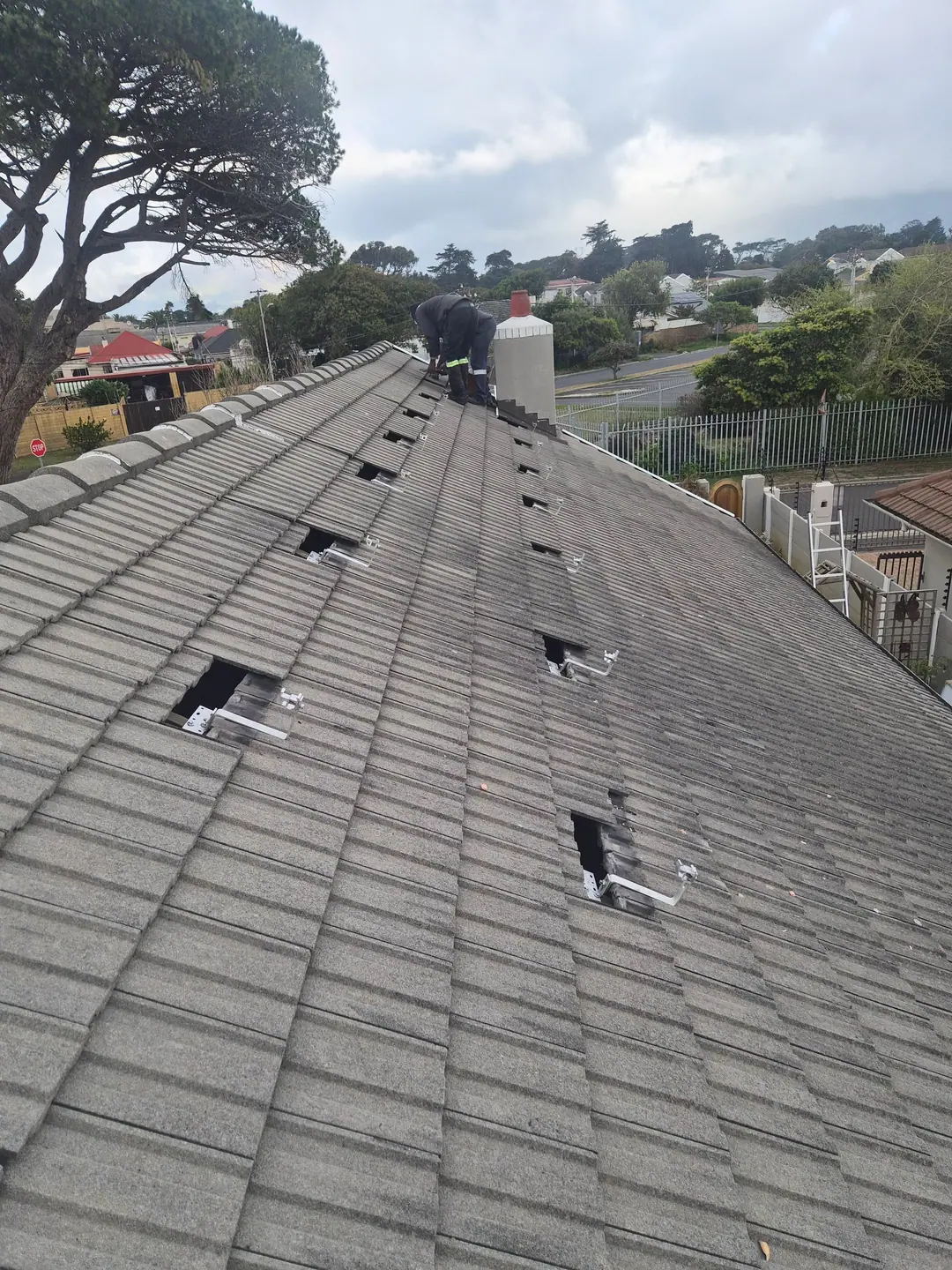 Roof tiles lifted and aluminium solar roof hooks fixed to the rafters
