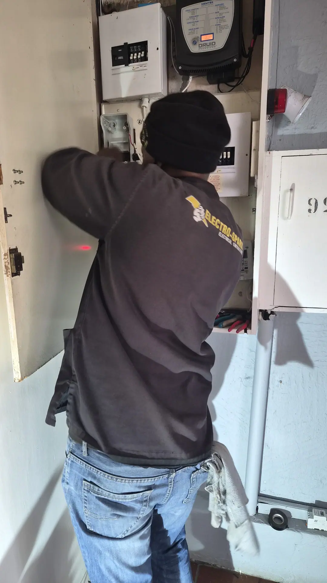 An Electro-Spark electrician working at a distribution board
